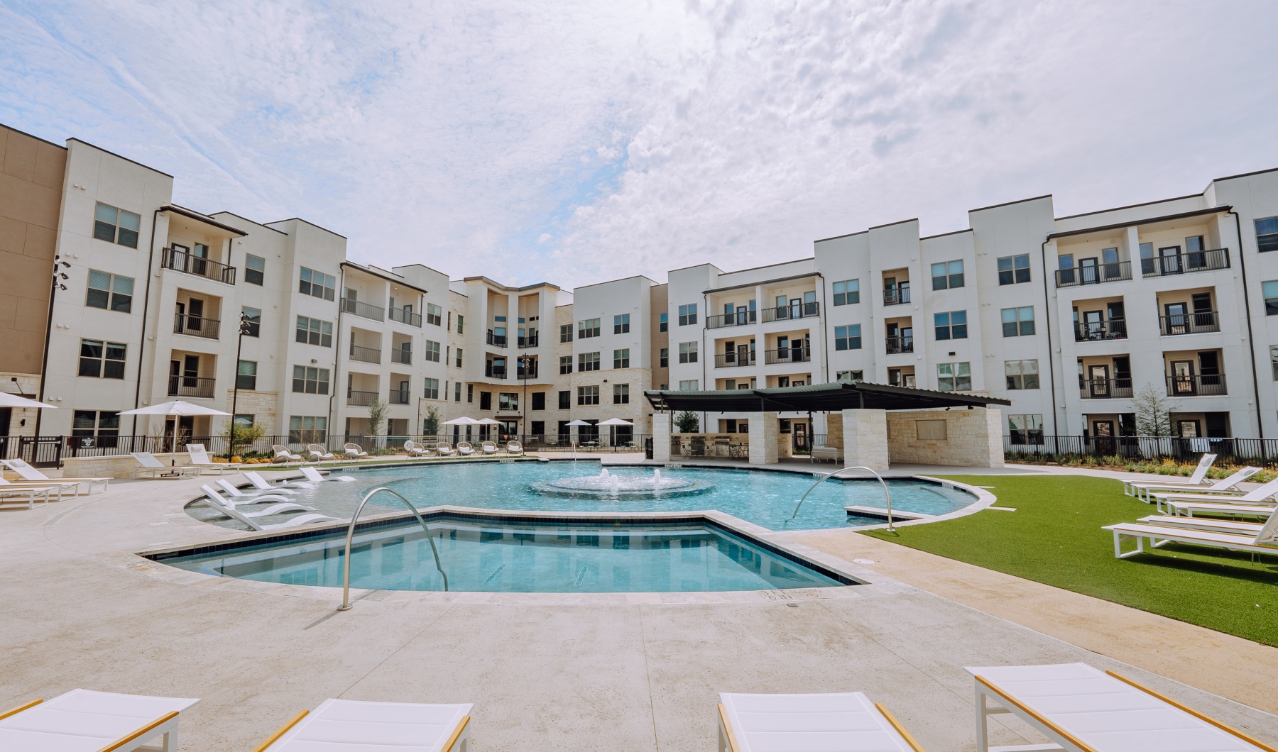 a pool courtyard with white lounge chairs